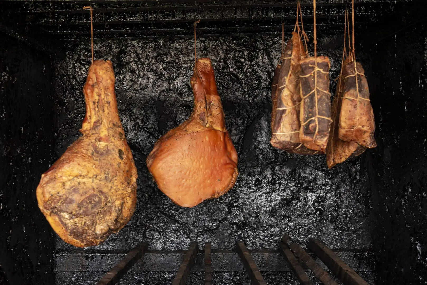Smoked hams hanging in a smokehouse