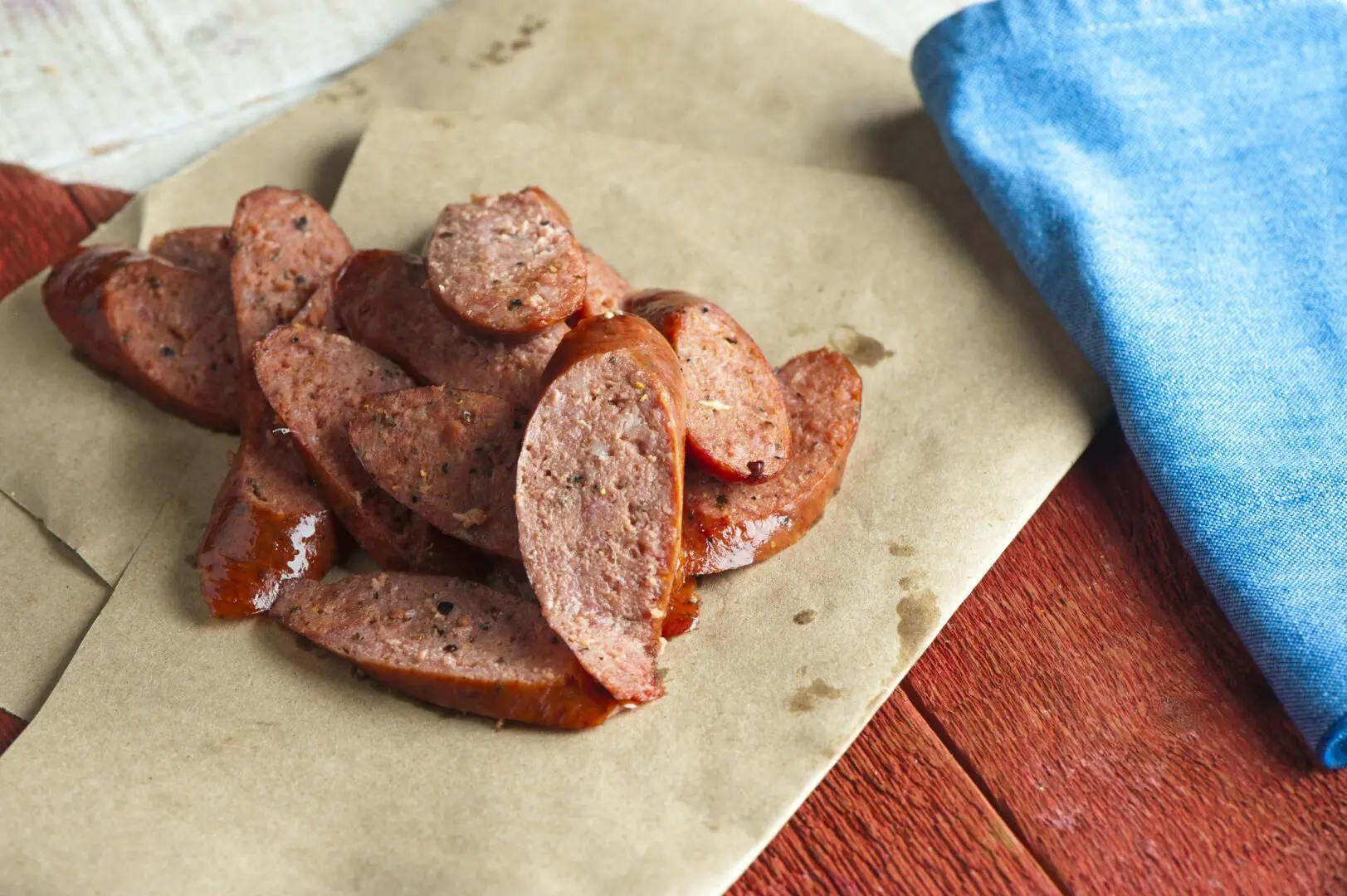 Sliced smoked sausage on brown paper napkin