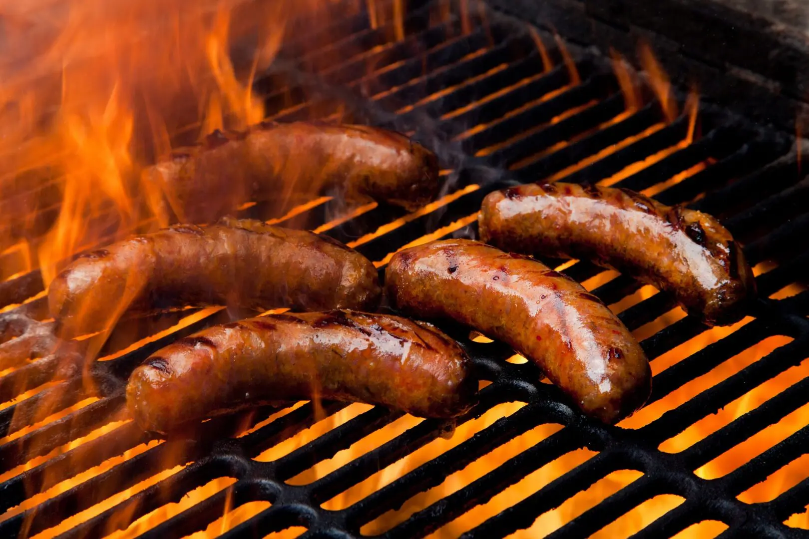 Sausages grilling over open flame