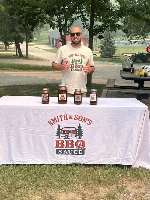 Man promoting BBQ sauce outdoors