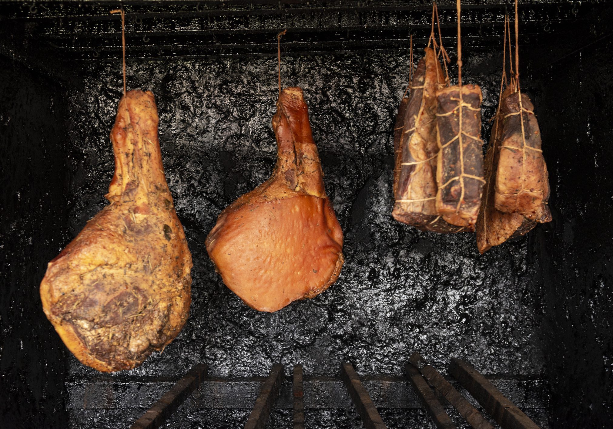 Smoked hams hanging in a smokehouse